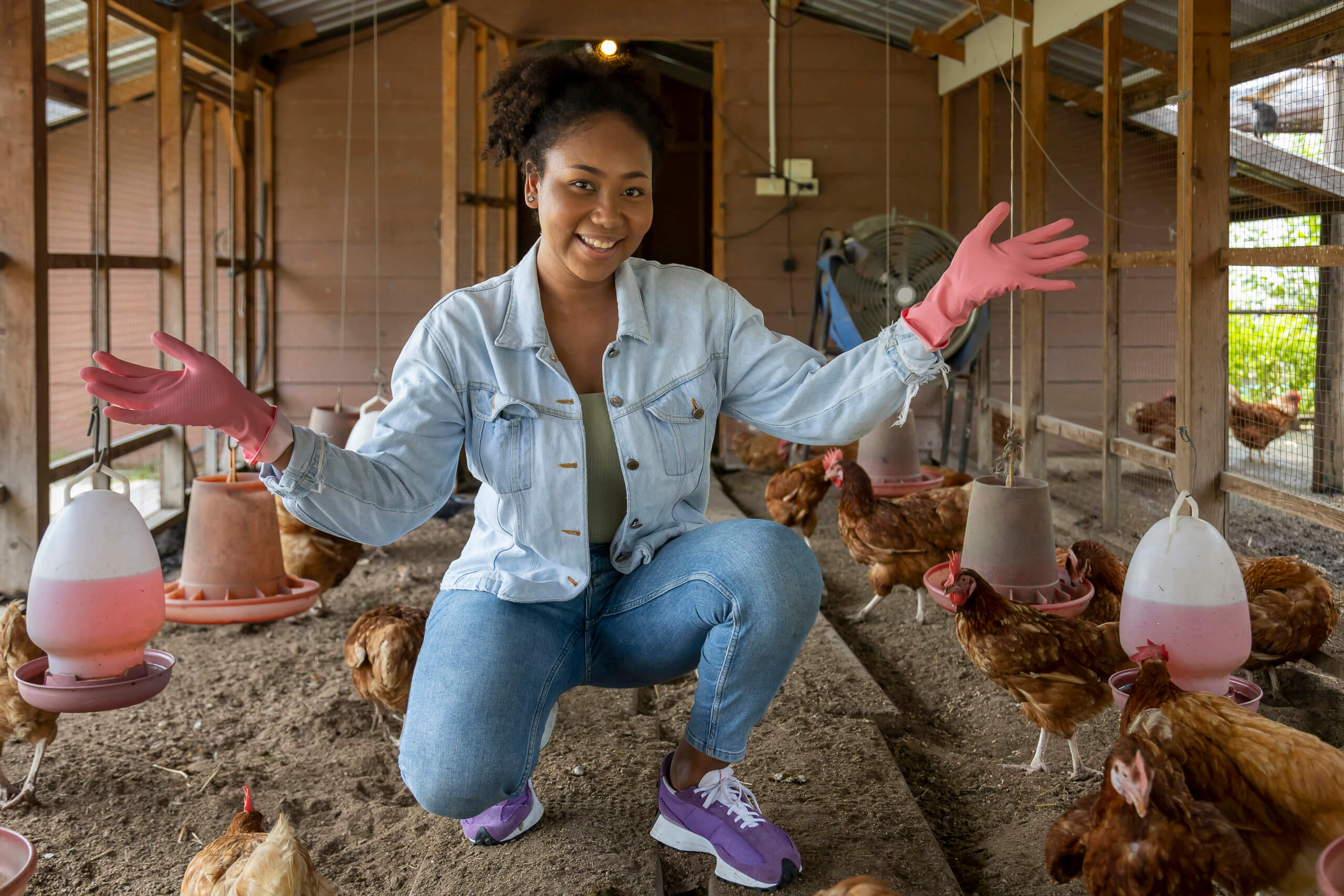 Black female farmer caring for chickens at her Georgia farm, representing the AgriUnity community